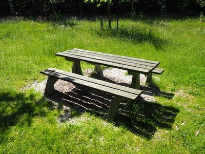 A water bottle and a towel on a wooden bench.